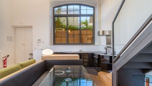 A modern kitchen with a large window, a glass table, and a staircase. - Internazionale Domus (Rome)