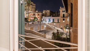 A nighttime view of a historic building with a central courtyard, a staircase, and surrounding architecture. - Internazionale Domus (Rome)