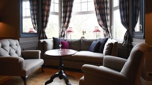 A cozy room with a sofa, two armchairs, and a small table. - Hotel Lafarques (Pepinster)