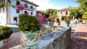 Une cour intérieure agrémentée de plantes en pot et un bâtiment blanc doté de balcons.