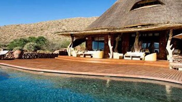 A thatched-roof building with a pool in front. - The Motse - Tswalu Kalahari Luxury Private Game Reserve (Kuruman)
