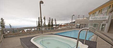 En swimmingpool med utsikt över ett berg och en byggnad med skylten "The Blaney Stone Irish Tavern".