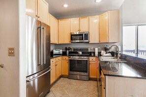 2-Bedroom Condominium #301A | Private kitchen | Fridge, microwave, oven, stovetop