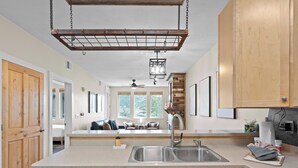 A modern kitchen with wooden cabinets, a stainless steel sink, and a dishwasher. - Crestview Condominiums by All Seasons Resort Lodging (Park City)
