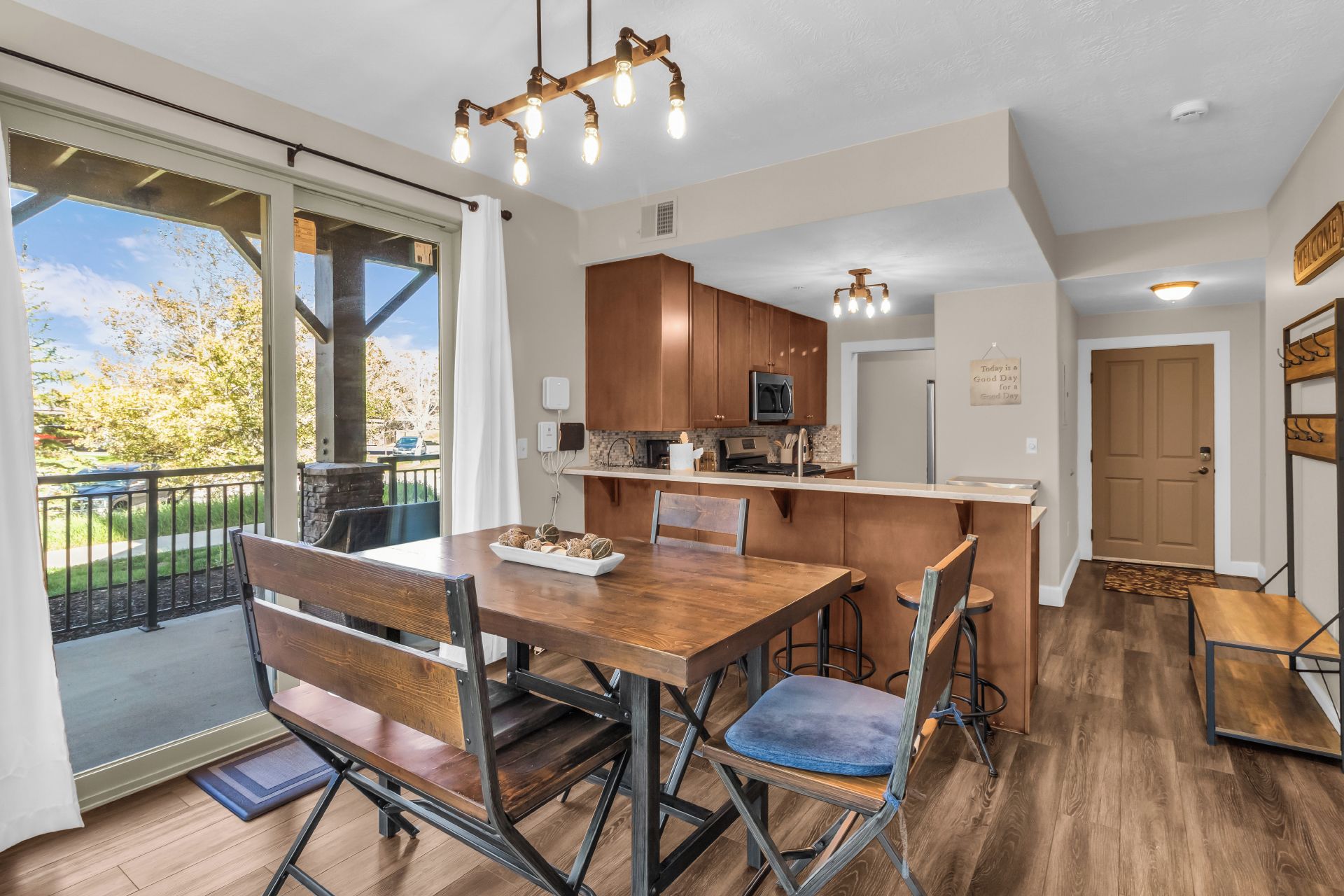 Une cuisine moderne avec des meubles en bois, un îlot central et un coin repas comprenant une banquette et des chaises.