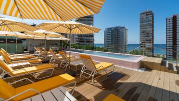 Piscina a l'aire lliure, para-sols i gandules