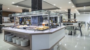 Un espace buffet doté d’un comptoir en marbre, d’assiettes et de divers plats.