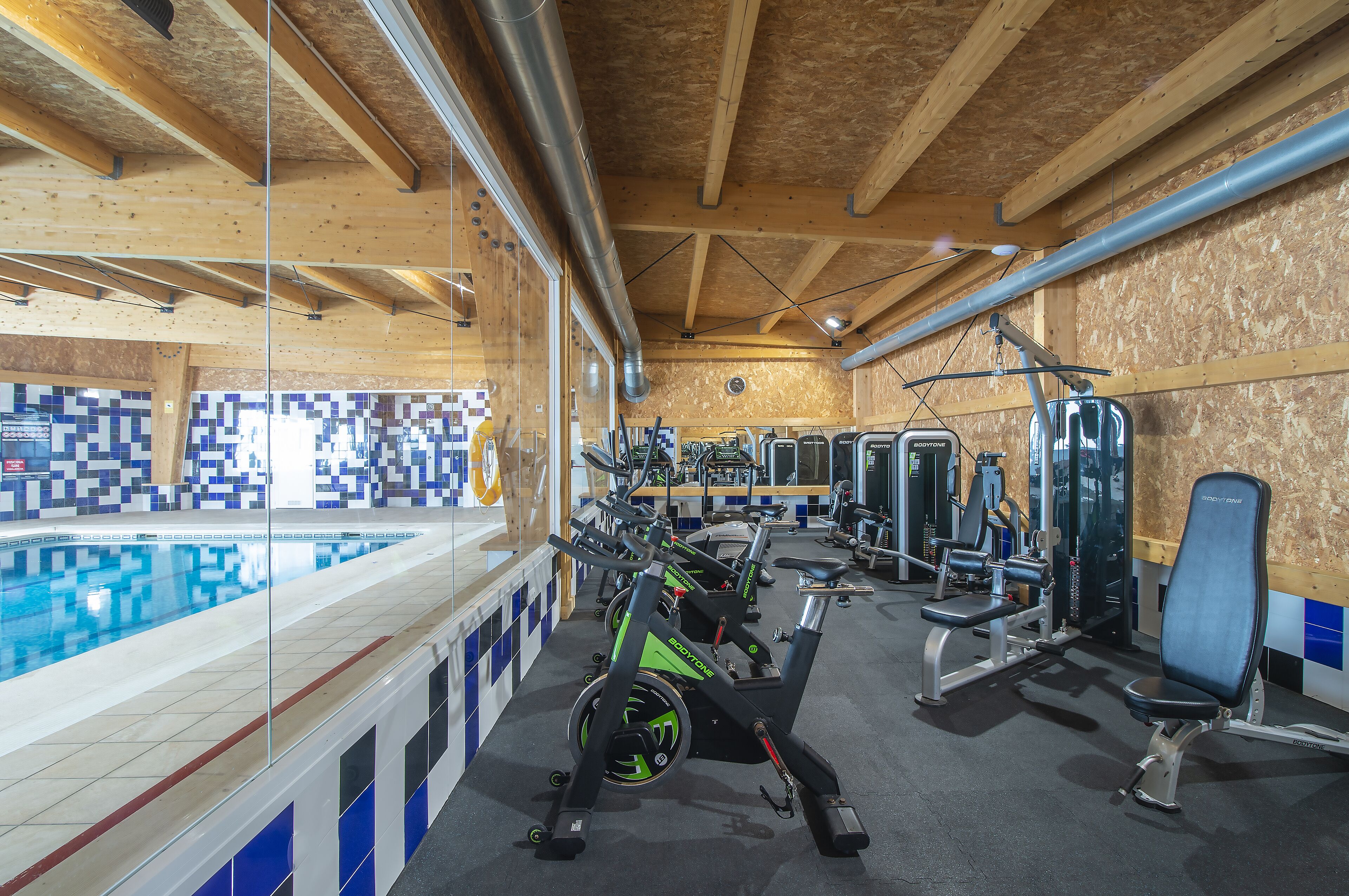 Una palestra con piscina, cyclette e macchinari per allenamento con i pesi.