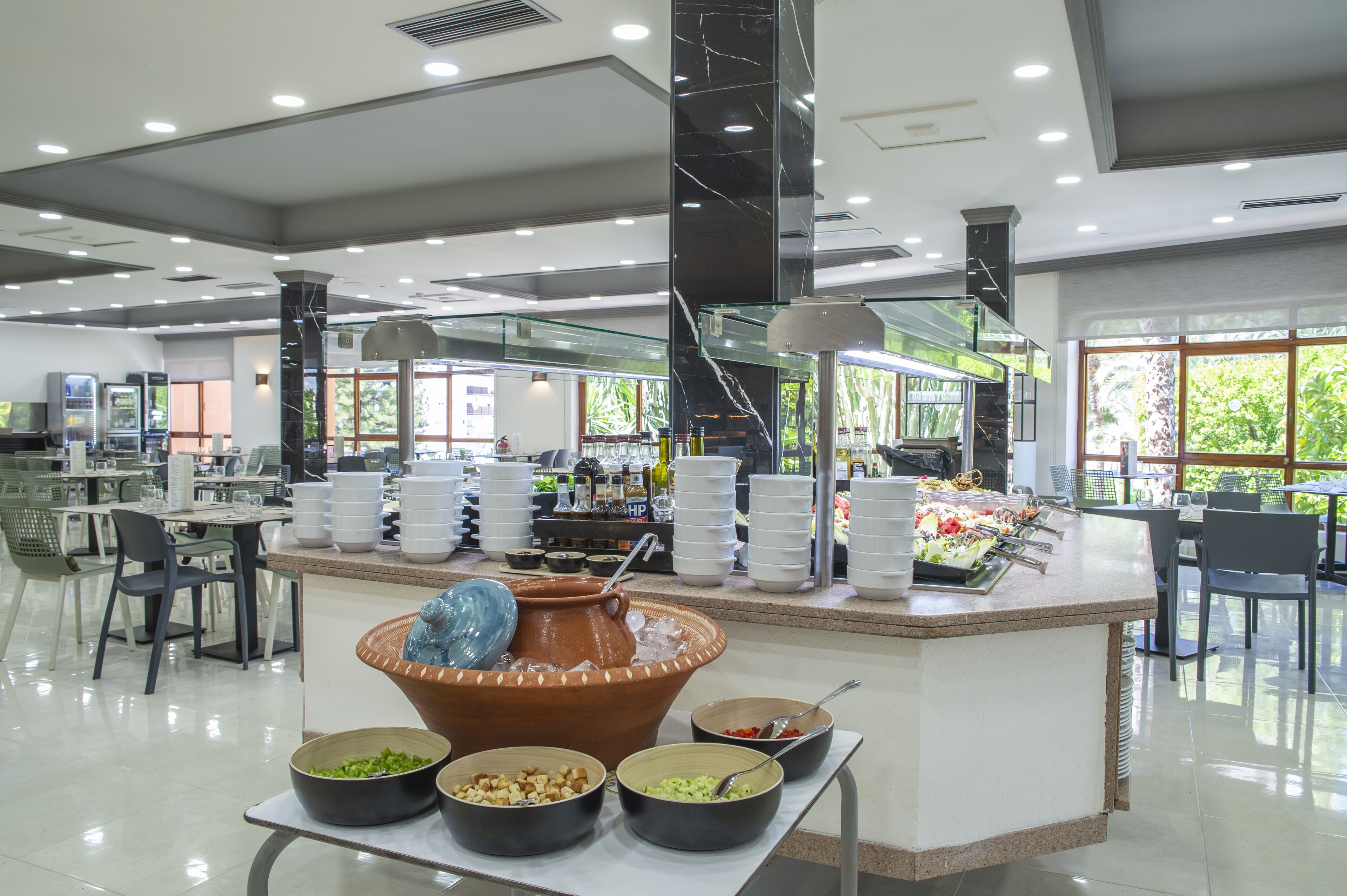 A buffet area with multiple serving stations, a large central serving bowl, and a variety of food items.