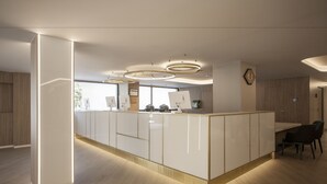 Una cucina moderna con isola centrale, illuminazione a sospensione e vista sull'esterno.