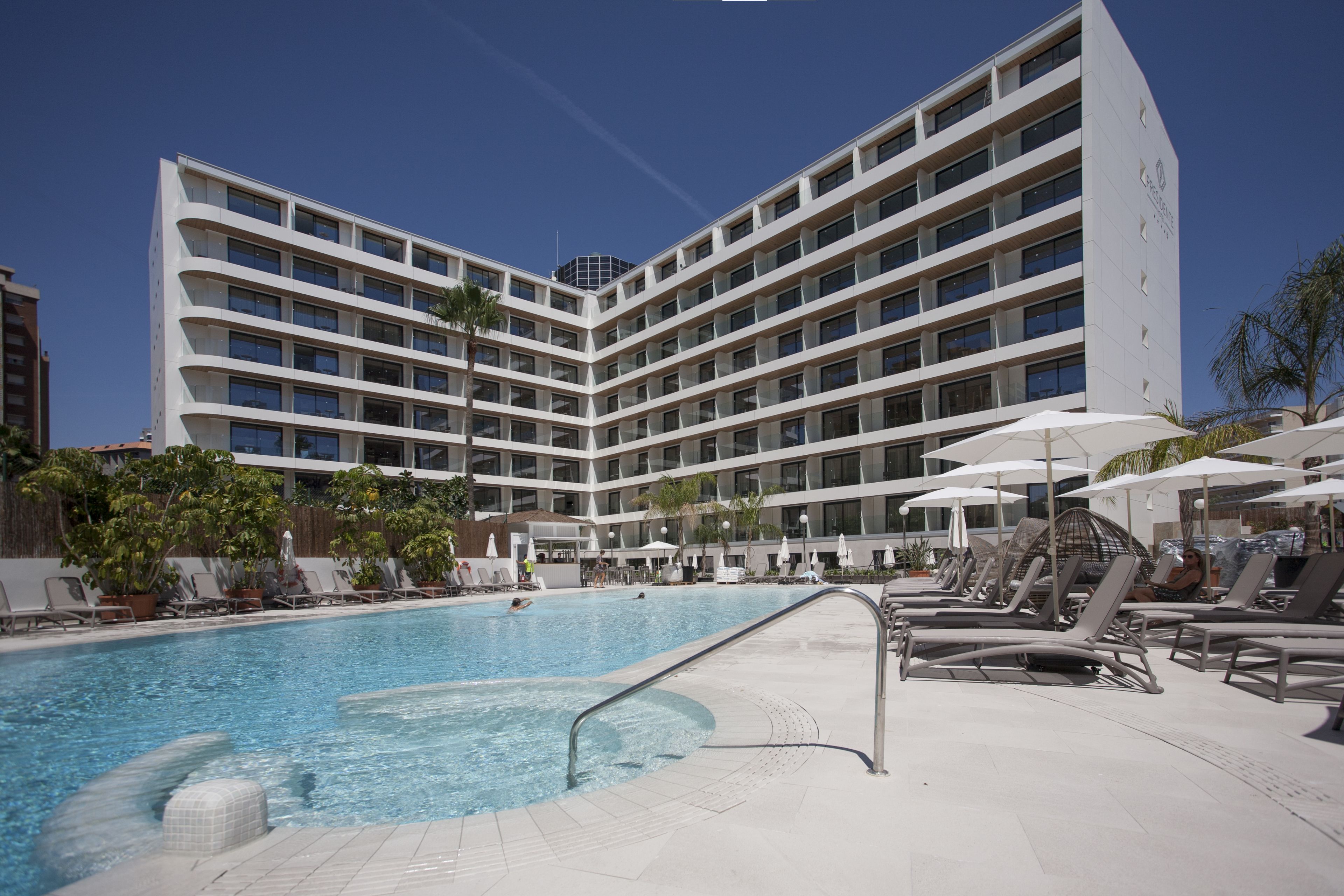 Een buitenzwembad, parasols voor strand/zwembad
