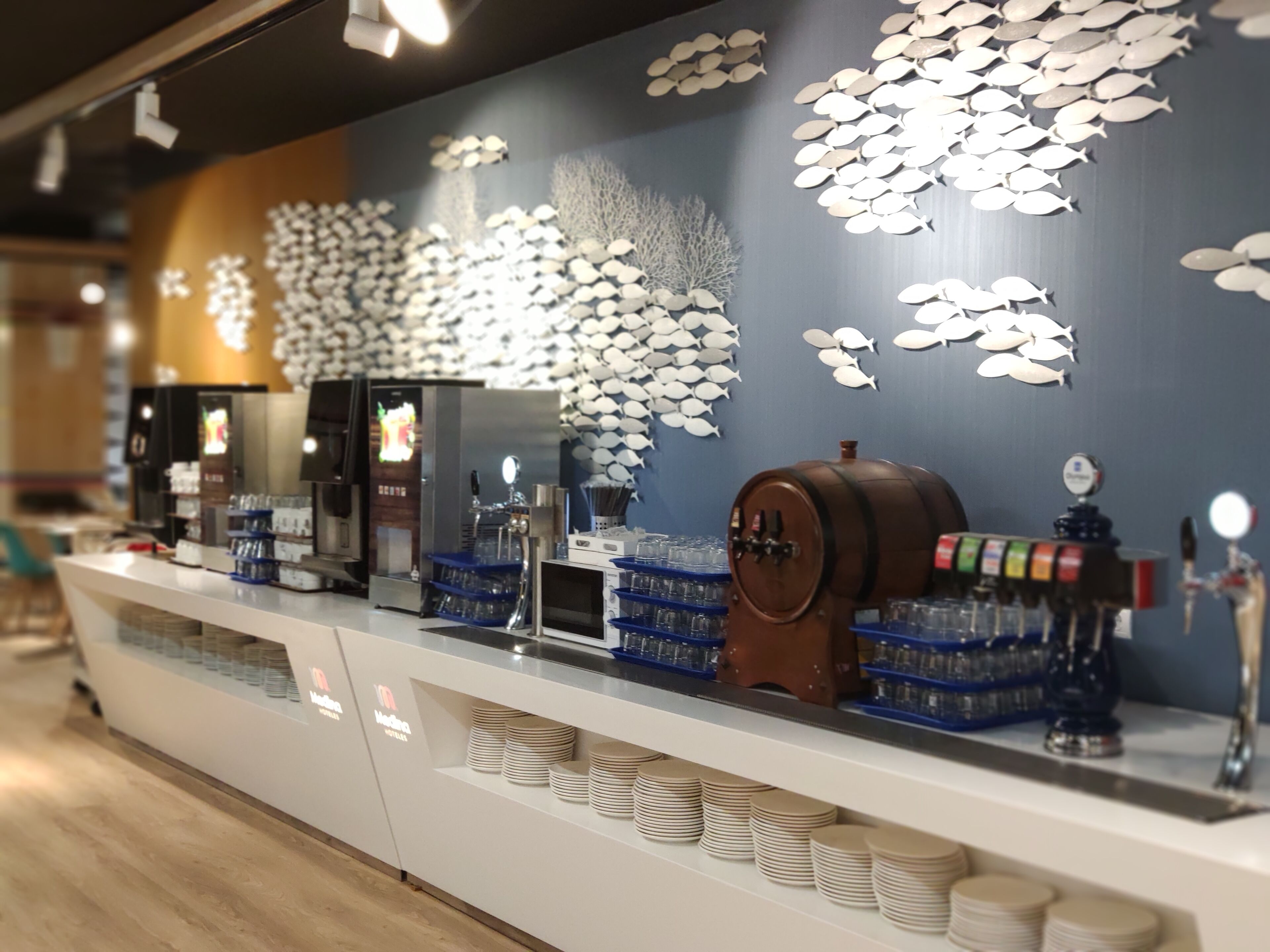 Una barra con una máquina de café, cristalería y un grifo de cerveza.