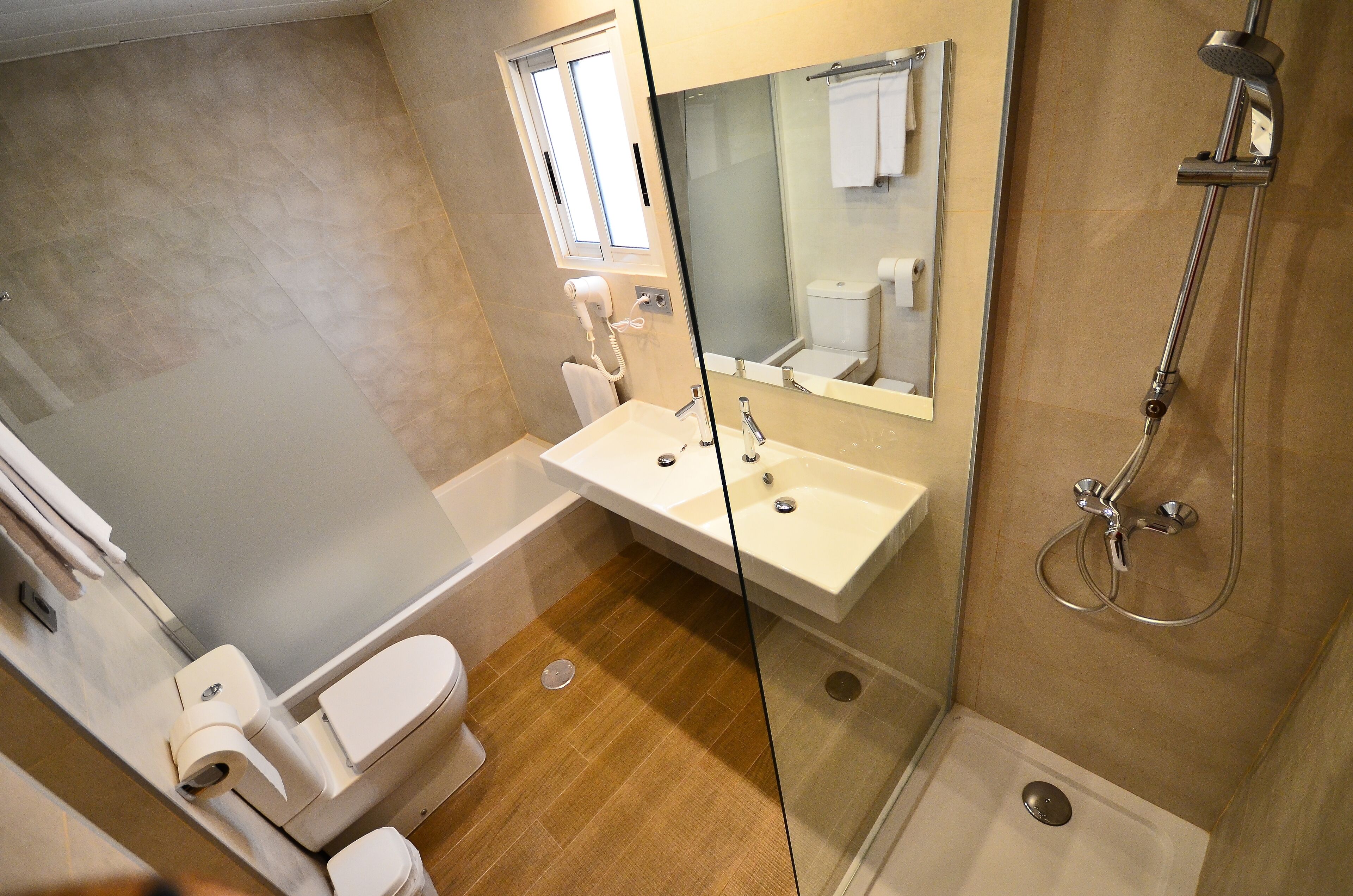 A modern bathroom with a bathtub, a shower, and a sink.