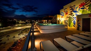 A rooftop pool area with lounge chairs and a decorative wall. - Hotel Carlos l (Benidorm)