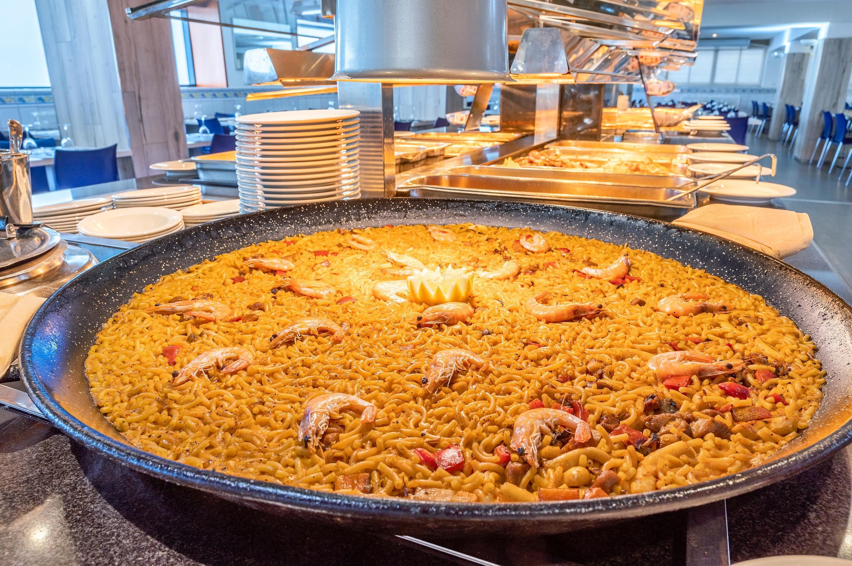 Eine große Paella-Pfanne mit Garnelen und Gemüse.