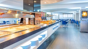 A buffet area with various food items and a seating area with blue chairs. - Port Fiesta Park Hotel (Benidorm)