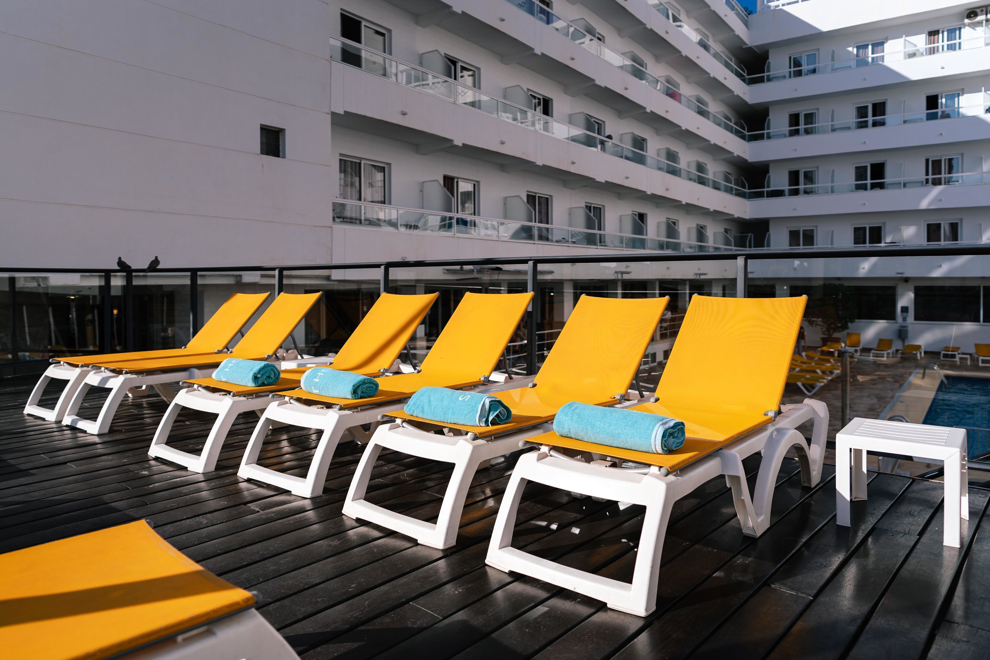 A poolside area with sun loungers and a pool.