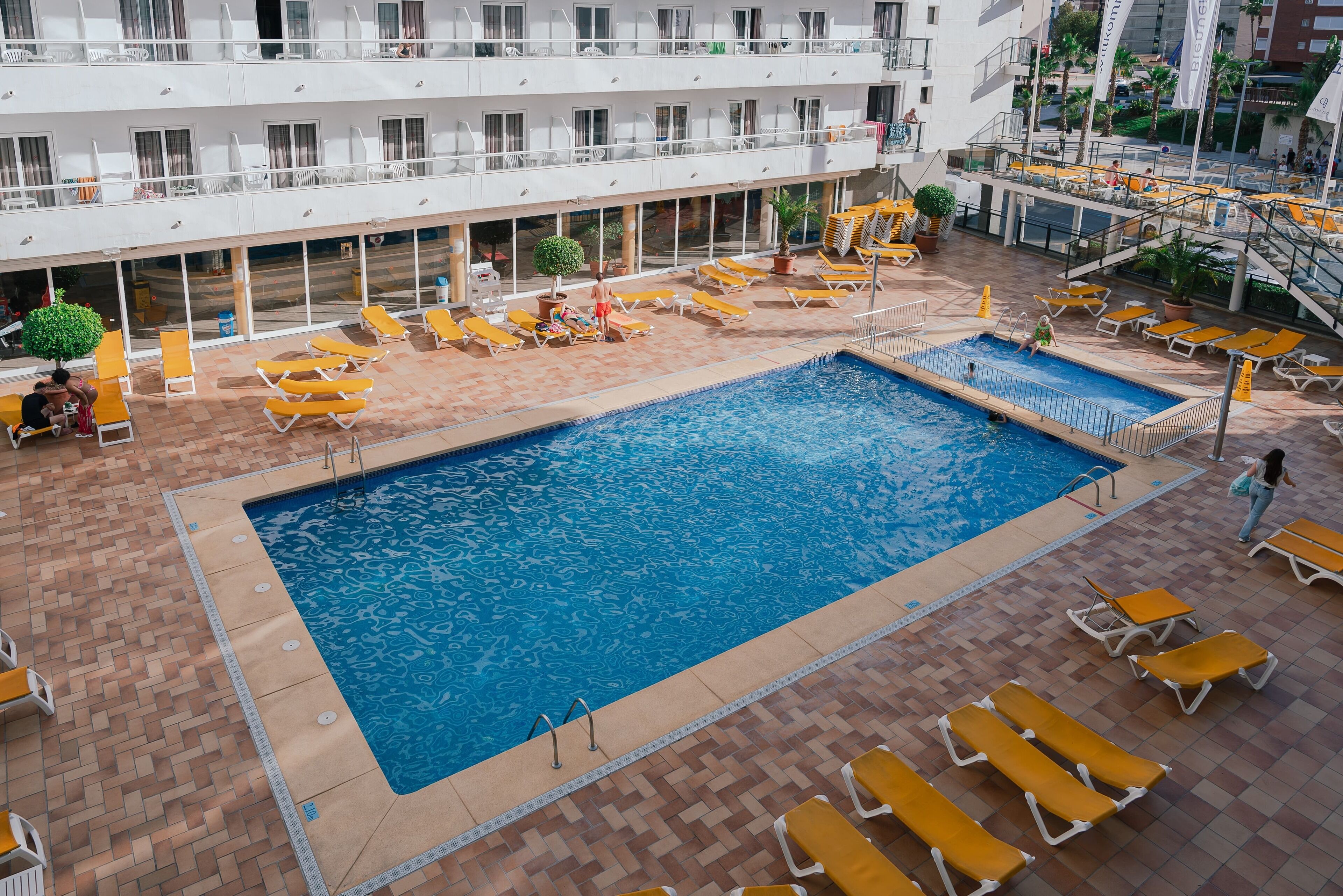 Zona de piscina en la azotea con múltiples tumbonas y una piscina.