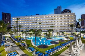 A hotel with a large pool, multiple floors, and a well-maintained lawn area. - Poseidon Resort (Benidorm)