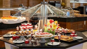 A buffet with various desserts and a decorative centerpiece. - Poseidon Resort (Benidorm)