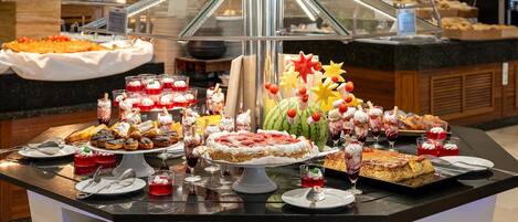 Een buffet met diverse desserts en een decoratief middelpunt.