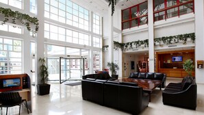 A spacious lobby with a reception desk, seating area, and a large windowed entrance. - Poseidon Resort (Benidorm)