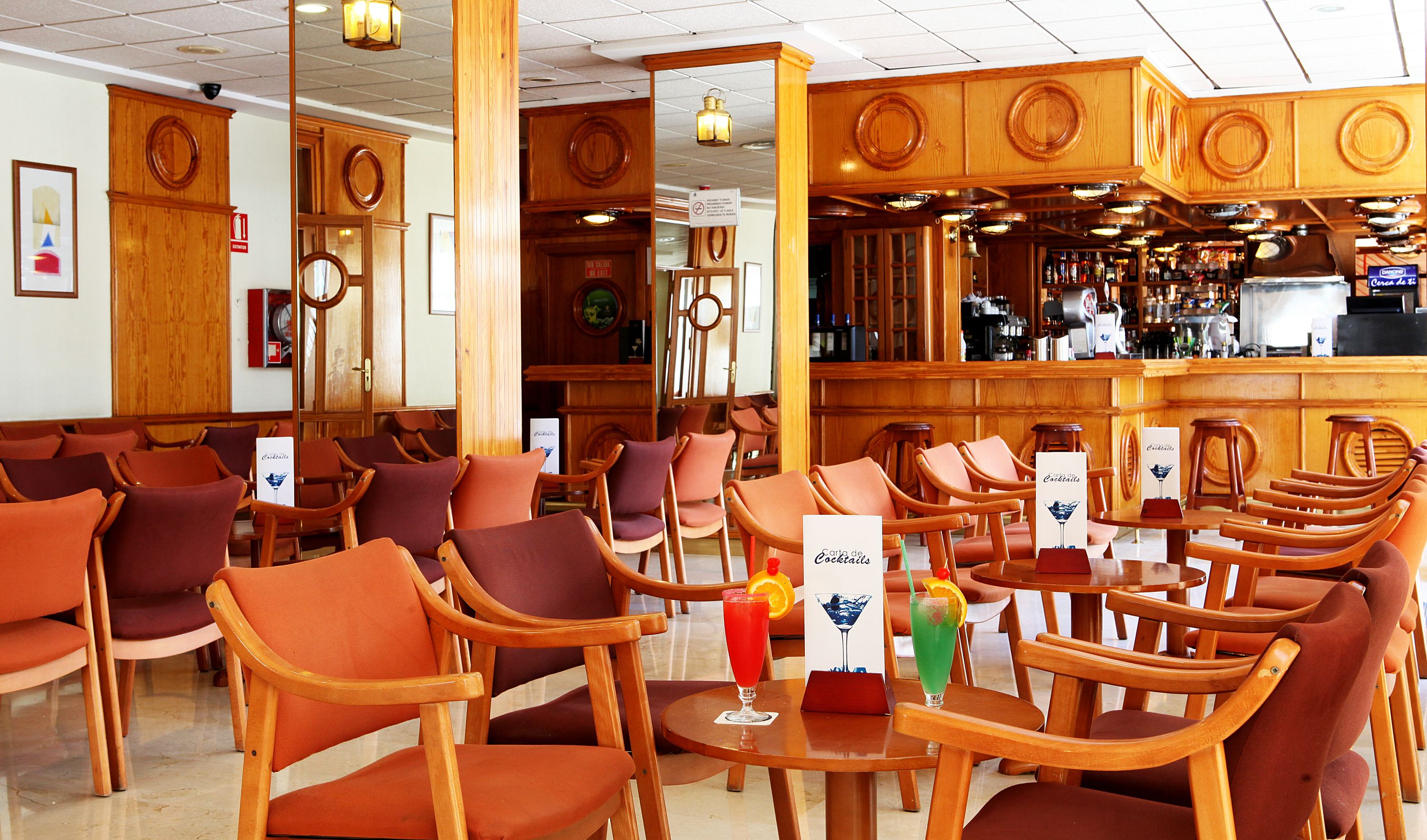 A bar area with wooden furniture and a bar counter.