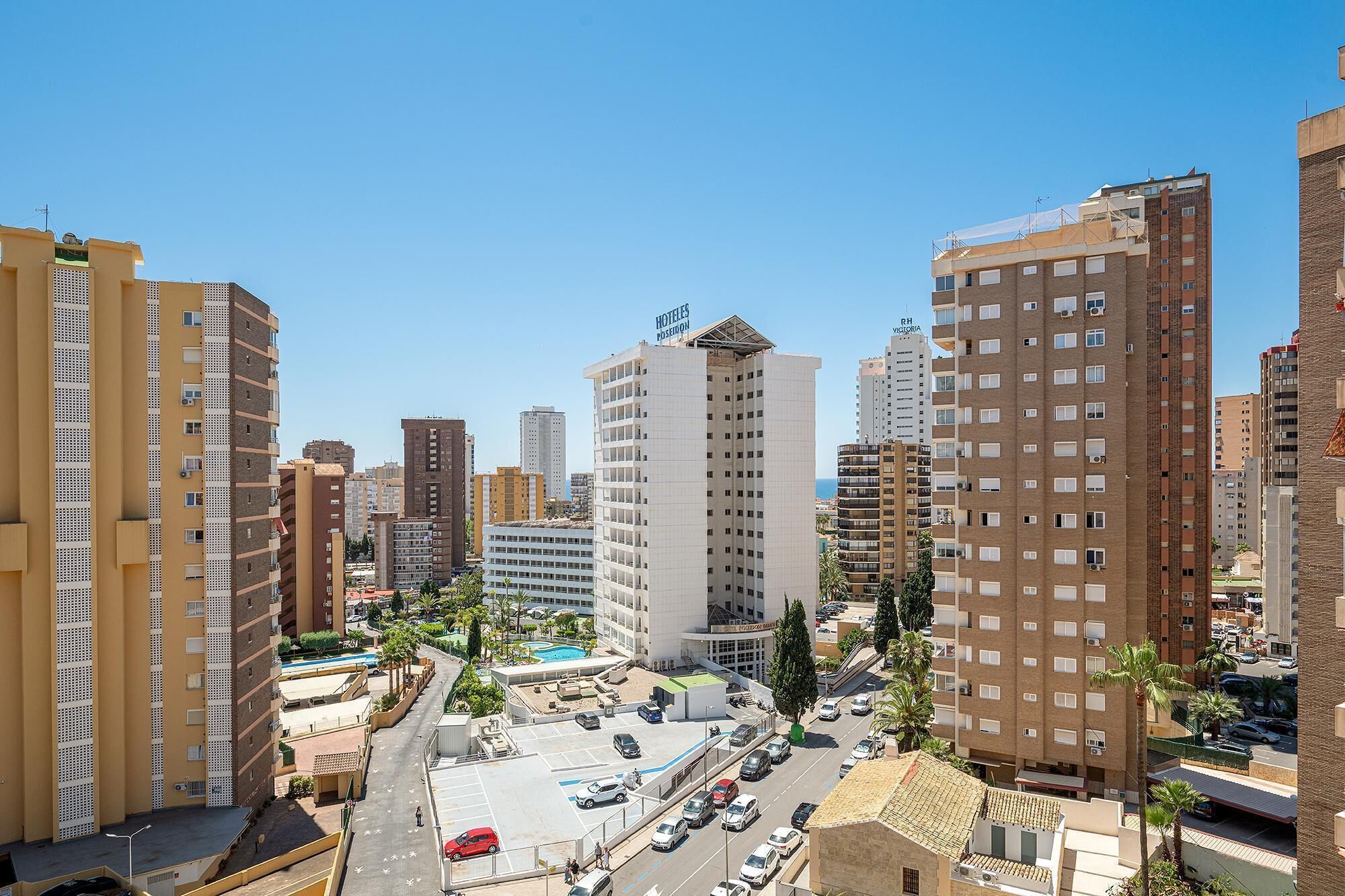 A high-rise hotel with multiple floors, a rooftop pool, and a view of the surrounding urban area.