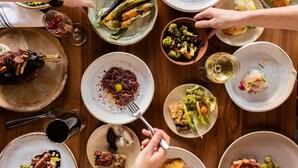 A variety of dishes on a wooden table, including roasted meats, vegetables, and salads. - Kimpton Marlowe Hotel by IHG (Cambridge)