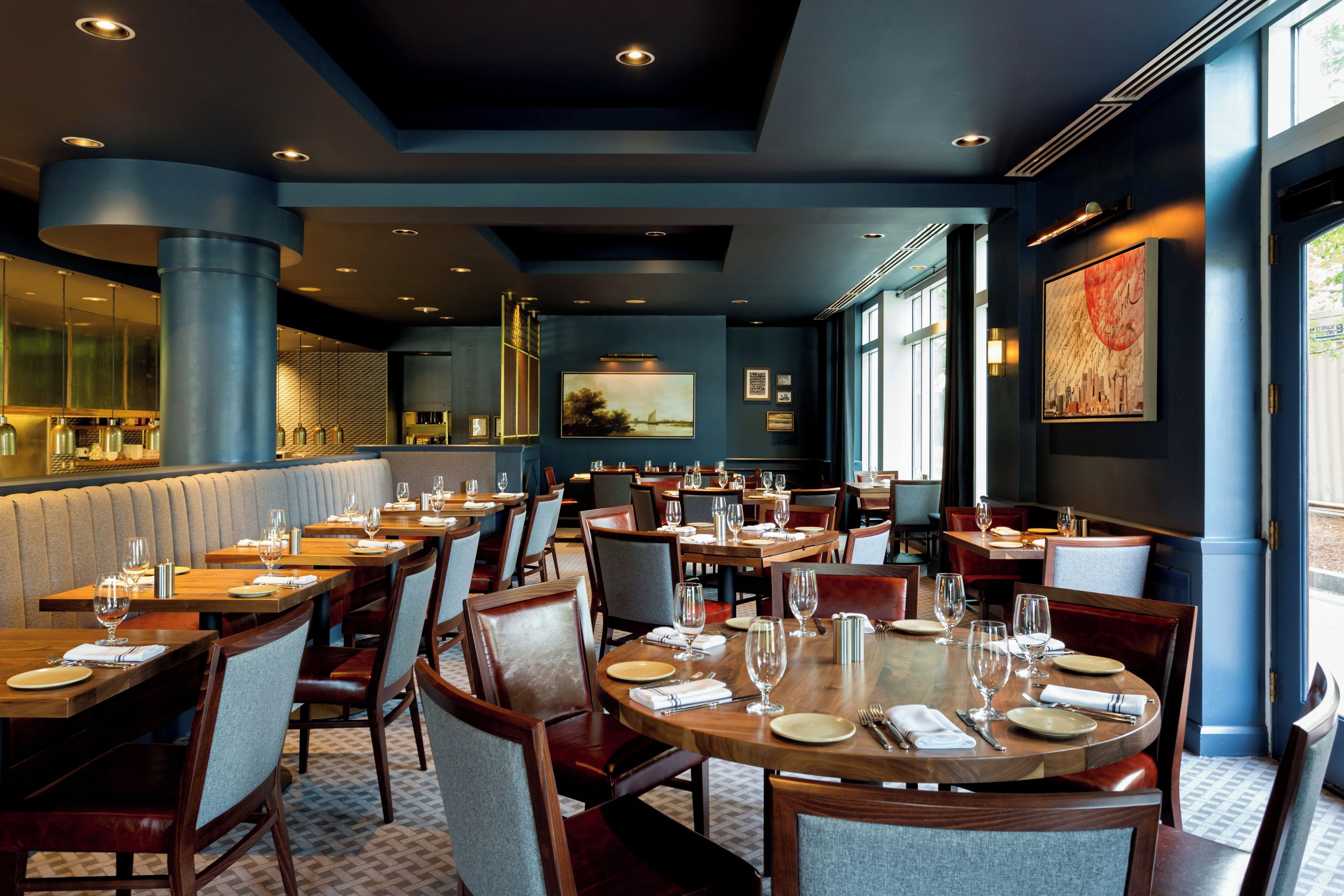 A restaurant interior with multiple dining tables, chairs, and a bar area.