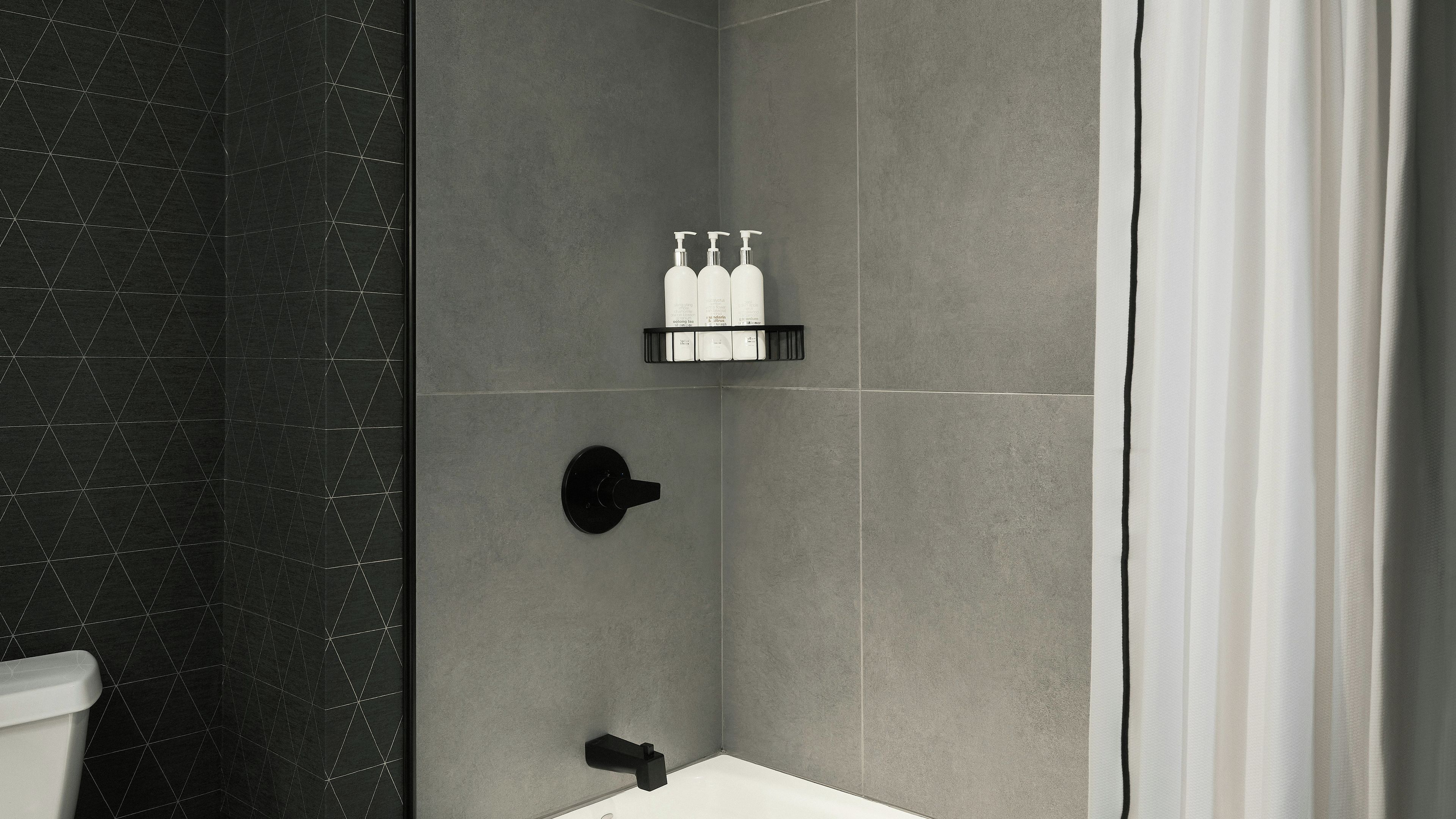 A modern bathroom with a shower area, a toilet, and a sink.