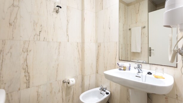A bathroom with a bidet, a sink, and a mirror. - Globales Cortijo Blanco (Marbella)