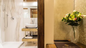 Un baño moderno con ducha de mármol, lavabo y tocador.