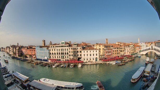 Vista panorámica de una ciudad histórica con un río, edificios y un puente.