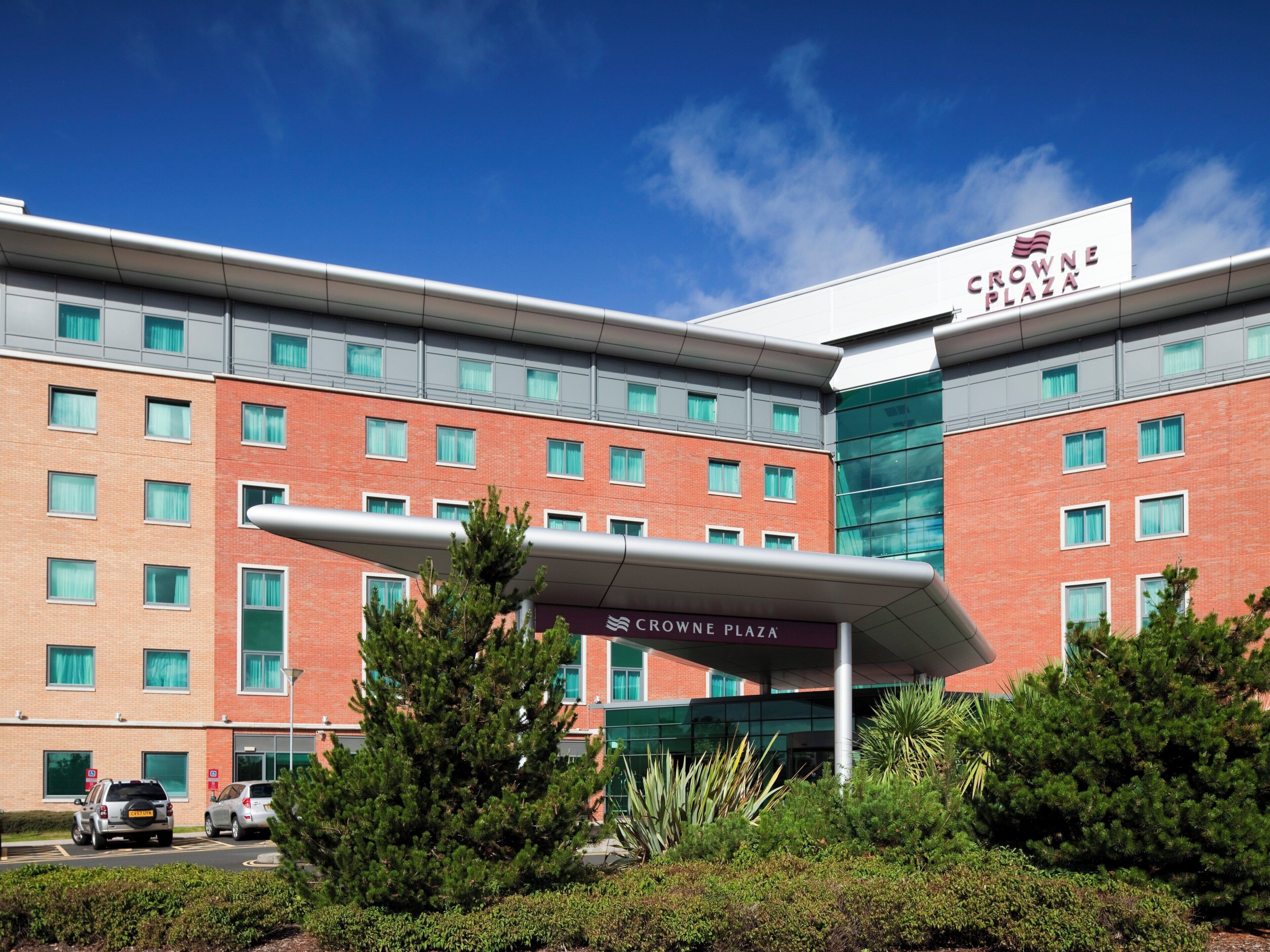 A hotel building with a sign reading 'Crowne Plaza' and a modern architectural design.