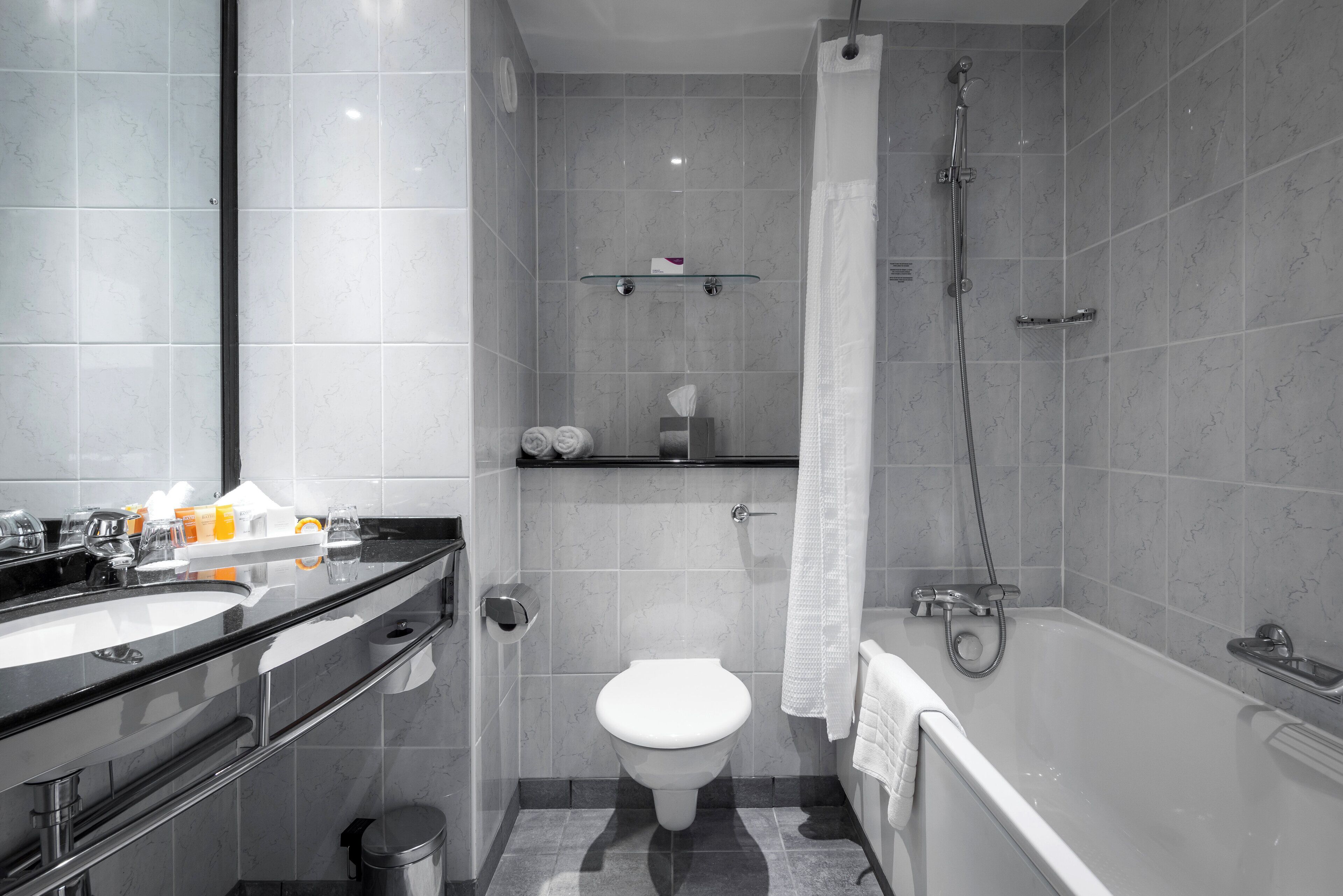A modern bathroom with a toilet, sink, and bathtub.