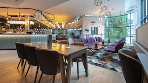 A modern bar area with a long counter and seating for guests. - Crowne Plaza Birmingham NEC by IHG (Birmingham)