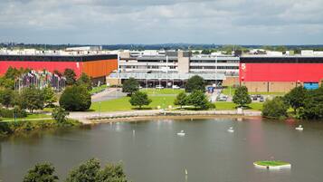 A large building with multiple floors and a red facade, surrounded by a body of water with several boats.