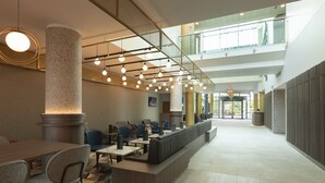 A spacious lobby with a long reception desk, seating area, and high ceilings with hanging lights. - Crowne Plaza Birmingham NEC by IHG (Birmingham)