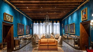 A room with a large sofa, a chandelier, and framed artwork on the walls. - Hotel Palazzo Priuli (Venice)