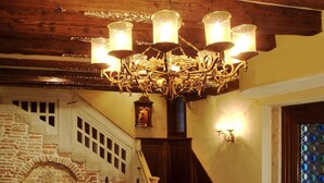 A grand staircase with a stone fireplace, a chandelier, and a stained glass window. - Hotel Palazzo Priuli (Venice)