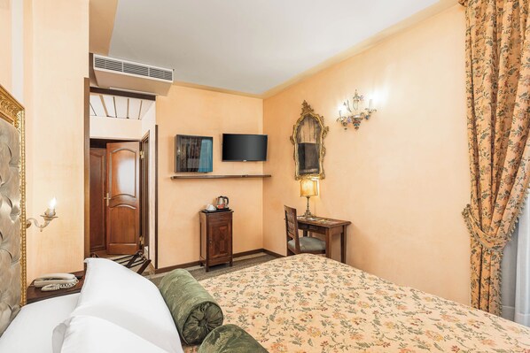 A hotel room with a bed, a desk, a chair, a television, a mirror, and a telephone. - Hotel Marconi (Venice)