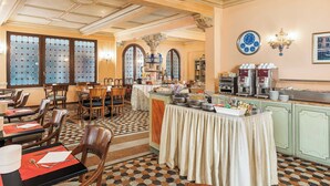 Un espace repas comprenant des tables, des chaises, un buffet et une horloge murale.