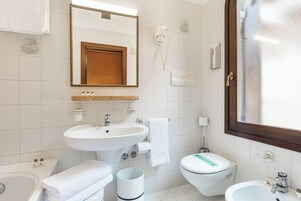 Un bagno con lavandino, wc, bidet e vasca da bagno.