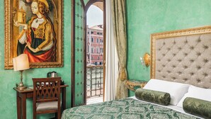 Une chambre d’hôtel avec un lit, une chaise, une table avec une lampe et un tableau au mur.