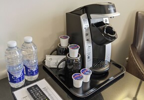 Una cafetera, dos botellas de agua Eska y dos tazas de Tim Hortons sobre una bandeja.