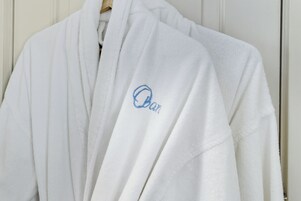 A white robe with a blue embroidered logo.