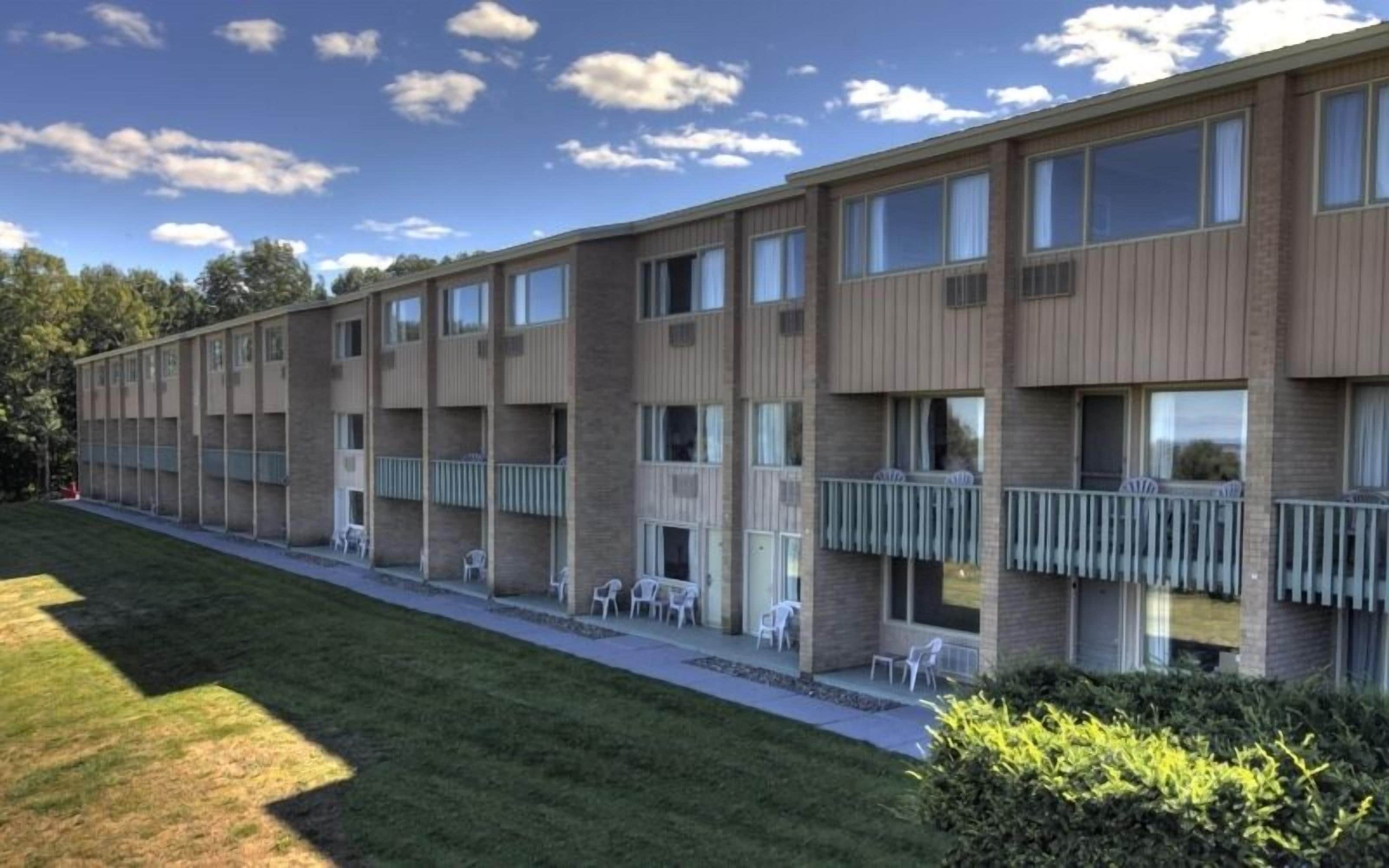 Un edificio moderno de varios pisos con balcones y zonas de estar al aire libre.