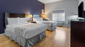 A hotel room with two beds, a desk, a TV, and a window with a city view. - Best Western Garden Inn (Bentleyville)
