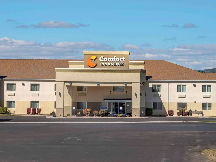 A Comfort Inn & Suites building with a clear entrance, multiple windows, and a parking lot in front.